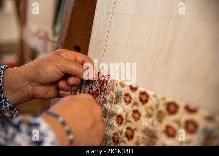 Tessitura di tappeti usando tecniche tradizionali su un telaio. , primo piano della tessitura e della produzione di tappeti fatti a mano. Foto Stock