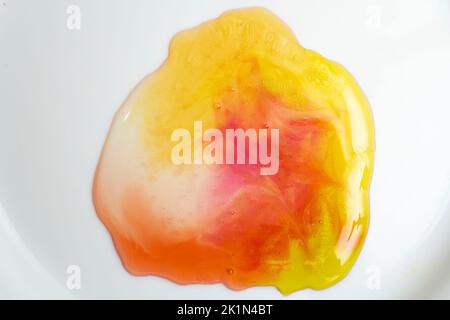 Orsi di gelatina multicolore fusi, su sfondo bianco. Primo piano con messa a fuoco morbida. Foto Stock