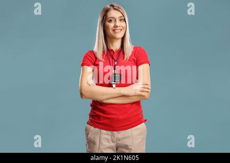 Allenatore di nuoto femminile con un wistle e cronometro intorno al collo isolato su sfondo blu Foto Stock