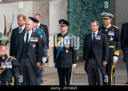 Il Duca di Sussex, il Duca di York, il Conte di Wessex e Peter Phillips guardano su come la carrozza di pistola di Stato che porta la bara della Regina Elisabetta II arriva a Wellington Arch durante la processione della cerimonia dopo il suo funerale di Stato all'Abbazia di Westminster, Londra. Foto Stock