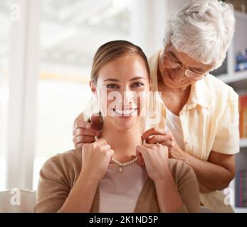 Perle per il mio prezioso. Una donna anziana che dà a sua figlia una collana di perle. Foto Stock