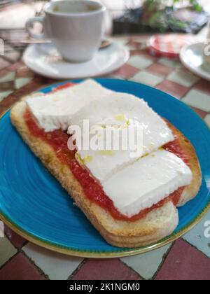 Pane tostato con formaggio e pomodoro sul tavolo a mosaico con piastrelle smaltate. Sfondo in stile arabo Foto Stock