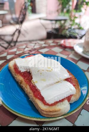 Pane tostato con formaggio e pomodoro sul tavolo a mosaico con piastrelle smaltate. Sfondo in stile marocchino Foto Stock