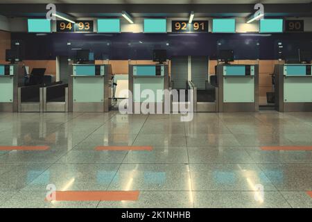 Una fila di cabine vuote per il check-in in un aeroporto internazionale con piccoli schermi LCD vuoti. Sportelli vuoti per il check-in dei passeggeri in un moderno aeroporto Foto Stock