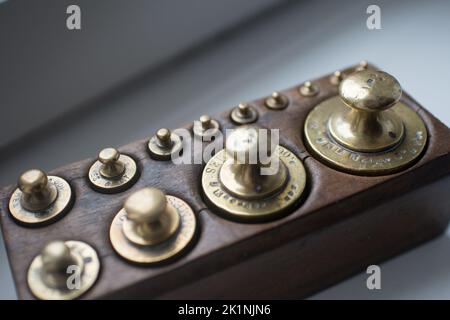 Set di pesi dorati tradizionali in una scatola di legno vista dall'alto Foto Stock