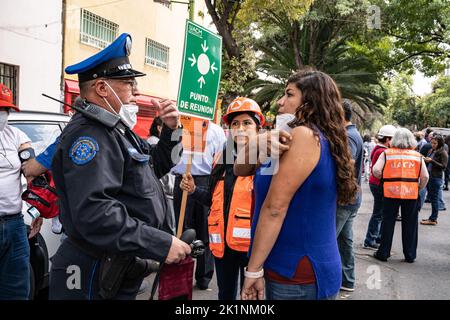 Città del Messico, Messico. 19th settembre, 2022. Un poliziotto controlla la pressione sanguigna di una donna visibilmente ansiosa che aveva recentemente evacuato a causa di un terremoto. La trivella è stata in memoria dei terremoti del 1985 e del 2017. Molte persone per strada hanno ricevuto cure mediche da ansia piuttosto che lesioni fisiche. Credit: Lexie Harrison-Cripps/Alamy Live News Foto Stock