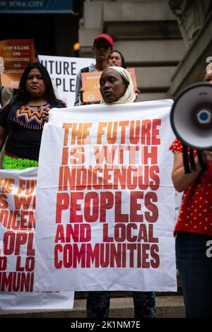 Un manifestante tiene un cartello con la scritta "il futuro è con le popolazioni indigene e le comunità locali" durante una dimostrazione davanti al museo degli Indiani d'America. I leader indigeni della Global Alliance of Territorial Communities hanno tenuto un dado davanti alla Borsa di New York chiedendo al settore finanziario di investire i $1,7 miliardi di dollari promessi entro il COP26 per proteggere le comunità in prima linea dal cambiamento climatico. I manifestanti hanno marciato dal Museo degli Indiani d'America seguendo un rituale sacro e diversi discorsi. Foto Stock