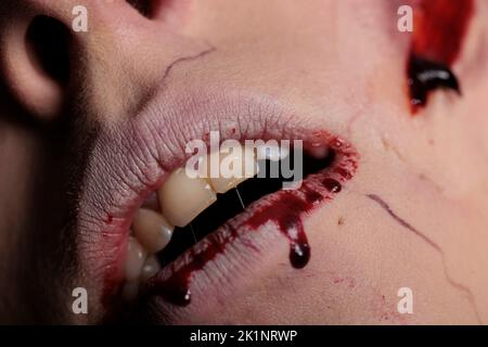 Zombie apocalittico con labbra e denti sanguinosi, mostrando bocca ferita con sangue sulla macchina fotografica. Spaventoso cervello male mangiare mostro con cicatrici e ferite, sporco sporco spooky graffi. Primo piano. Foto Stock