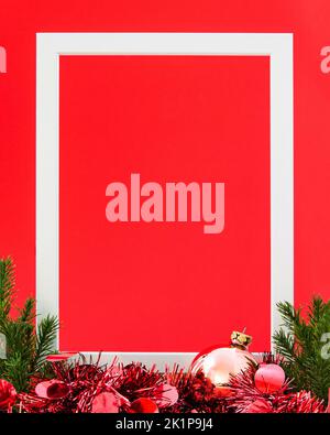 Banner rosso di Natale con cornice bianca, bauble, verde albero di Natale e decorazione. Concetto e idea. Foto Stock