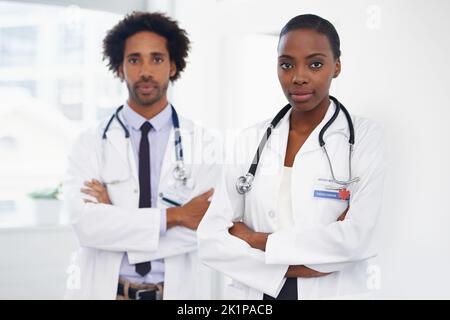 Theyre serio circa essere riuscito nella medicina. Ritratto di due medici in piedi in una stanza. Foto Stock