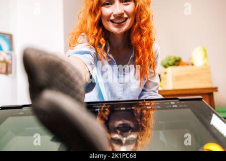 La casalinga allegra raggiunge fuori per prendere la torta gustosa dal forno con un sorriso grande sul suo volto. Foto Stock