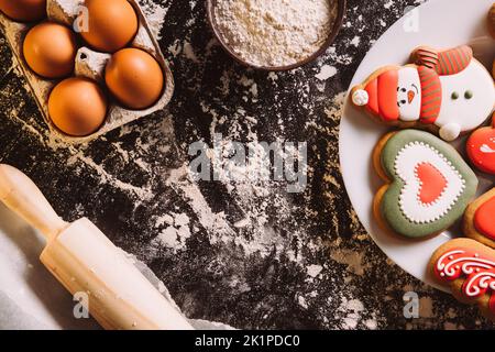 Sfondo cibo di Natale. Panetteria decorata in stile festivo. Biscotti fatti in casa. Pan di zenzero figurato glassa biscotti cuore innevatore alimenti ingredienti rolling pin f Foto Stock