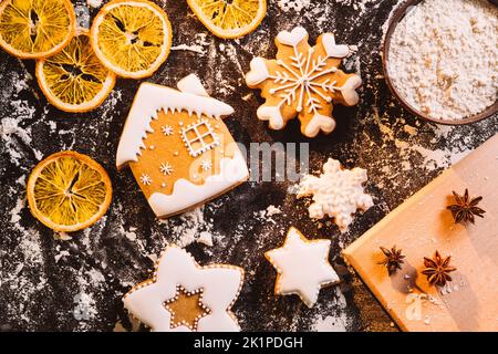 Panetteria invernale festosa. Biscotti tradizionali di Natale. Cucina casalinga. Pan di zenzero glassa pasticceria casa stelle su farina polvere essiccata arancia spezie bl Foto Stock