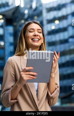 Ritratto di una donna di successo utilizzando un tablet digitale su sfondo urbano. Concetto di persone d'affari Foto Stock