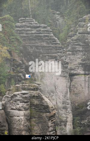 Un colpo verticale di formazioni di arenaria con una bandiera ceca nel Paradiso Boemo in Repubblica Ceca Foto Stock