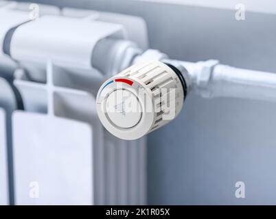 Termostato del radiatore di riscaldamento impostato a bassa temperatura, simbolo per risparmiare sui costi di riscaldamento. Crisi energetica, efficienza energetica e aumento dei costi di riscaldamento Foto Stock