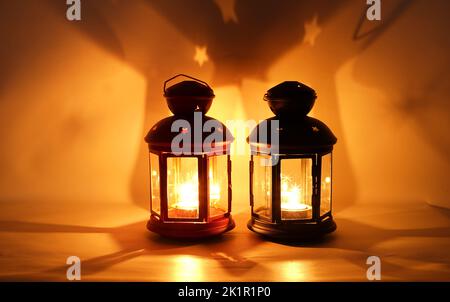 Incenso bruciatore censitore con fumo e sfondo bianco. Ornamentale lanterna araba con candela incandescente in mano. Foto Stock