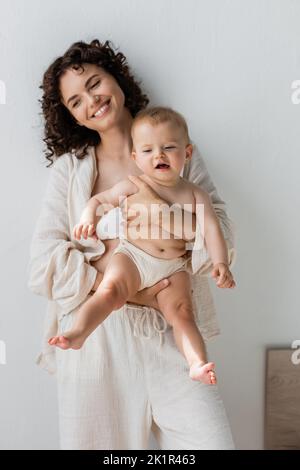 Donna felice in pigiama che tiene la ragazza del bambino nel paese, immagine di riserva Foto Stock