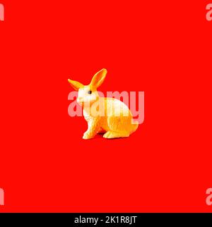 Coniglietto giallo su sfondo rosso. Idea di banner concettuale per il Capodanno cinese del coniglio. Foto Stock
