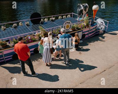 Turisti estivi che acquistano gelato alla barca stretta Full Moo Ice cream sul fiume Ouse, York, North Yorkshire, Inghilterra, Regno Unito Foto Stock