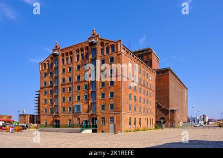 Scena quotidiana e turistica e paesaggio urbano nel Vecchio Porto, di fronte a uno storico edificio magazzino, Wismar, Germania. Foto Stock