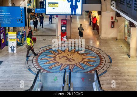 Persone e una guardia di sicurezza camminano nella sala principale della stazione degli autobus di Barcellona Nord. Vista ad angolo alto. Foto Stock