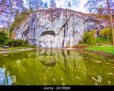 Leone di Lucerna monumento in pietra nella roccia con laghetto commemorativo a Lucerna, Svizzera Foto Stock