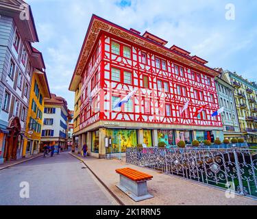 LUCERNA, SVIZZERA - 30 MARZO 2022: Edificio panoramico con pitture murali ornamentali sulla riva del fiume Reuss, il 30 marzo a Lucerna, Svizzera Foto Stock