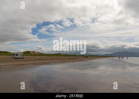 Inch Strand, Irlanda - 5 agosto, 2022: Guida a motore lungo l'infinita spiaggia sabbiosa di Inch Strand nella baia di Dingle con la bassa marea Foto Stock