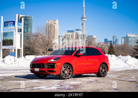 A Red Porsche Cayenne in un parcheggio basso in una giornata di sole durante l'inverno Foto Stock