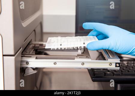 Lo scienziato carica i campioni in un termociclatore RT-PCR presso il laboratorio. Tecnica di reazione a catena della polimerasi in tempo reale. Tecnica RT-PCR Foto Stock