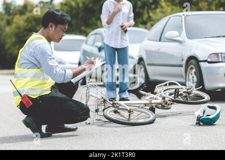 donna conducente shock con incidente auto ha colpito la bicicletta sulla strada reclamo poliziotto di lavoro raccolta dati sulla scena Foto Stock