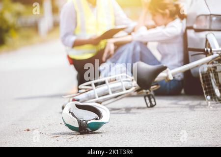 Incidente di bicicletta colpito da auto sulla strada autostrada scena conducente seduto assicurazione personale aiutare sostegno Foto Stock