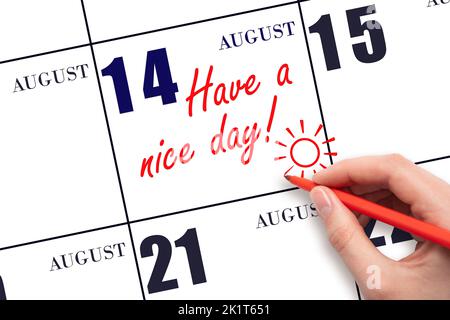 14th° giorno di agosto. La mano che scrive il testo hanno un bel giorno e disegnare il sole sulla data di calendario 14 agosto. Salvare la data. Mese estivo, giorno di Foto Stock