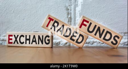 Su uno sfondo bello, blocchi di legno con il testo ETF Exchange Traded Funds. Fabbricazione di giocattoli in legno. Foto Stock