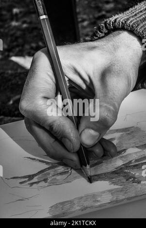 La mano dell'artista disegnando un disegno a matita. Primo piano.Bianco e nero Foto Stock