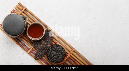 Composizione con tè sano puer su sfondo chiaro con spazio per il testo, vista dall'alto Foto Stock