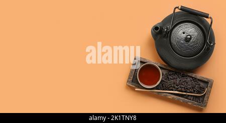 Composizione con gustoso tè puer su sfondo arancione con spazio per il testo, vista dall'alto Foto Stock