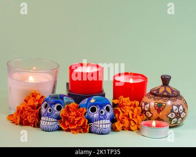 Spagnolo messicano tradizionale festa autunnale giorno dei morti tipico cranio messicano con fiori dipinti su sfondo verde, decorazioni e marigold Foto Stock