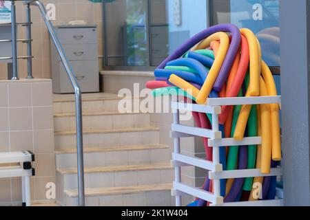 Pool stick extracurricular poliuretano colorato concorso lezione di nuoto nuotatore, gara concettuale al coperto in pullman dal centro di nuoto, fitness digitale Foto Stock