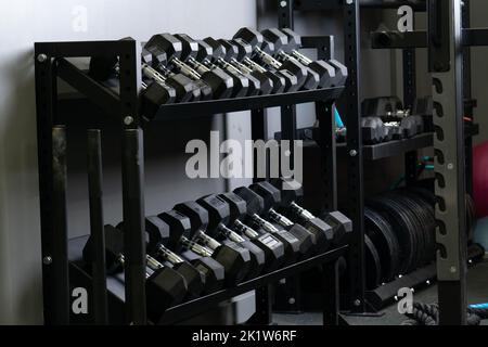 Dumbbell casa parete palestra blurry set di stoccaggio strongman attrezzature, da palestra per il nero per bodybuilder sano, peso bodybuilding. , Foto Stock