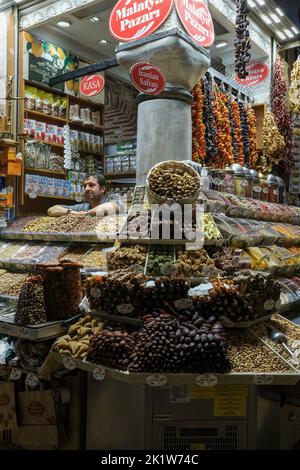 Il proprietario del negozio di spezie è visto accanto ai suoi prodotti mentre aspetta i clienti. Situato nel quartiere Eminönü di Istanbul, lo storico Bazaar delle spezie continua ad essere un centro commerciale preferito dai turisti locali e stranieri. E' un luogo distinto dove turisti da tutto il mondo possono fare acquisti e gustare prelibatezze specifiche del paese. Foto Stock