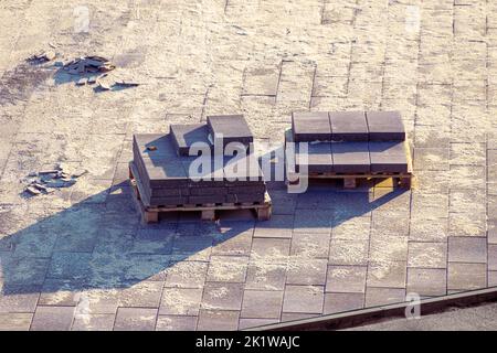 le lastre di pavimentazione quadrate di una miscela di cemento giacciono su pallet, tra i focus quadrati e selettivi Foto Stock