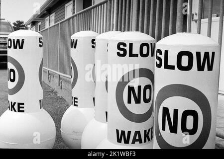 Coast Guard bouys Reading SLOW NON SVEGLIATI in un parcheggio a Gloucester Harbor, Massachusetts. L'immagine è stata acquisita in bianco e nero analogico Foto Stock