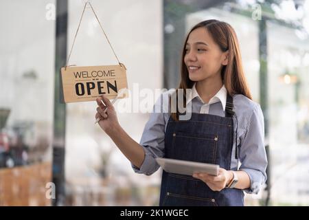 Benvenuto open shop barista cameriera aperto segno su porta di vetro moderna caffetteria pronto a servire ristorante caffetteria retail piccoli imprenditori. Foto Stock