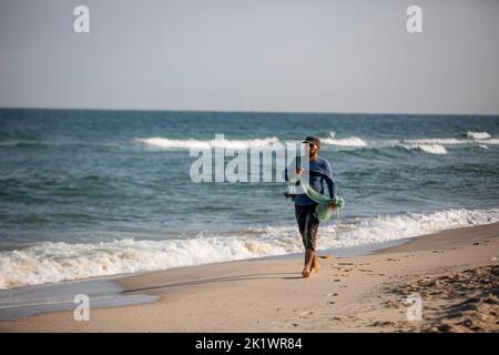 Gaza, Palestina. 20th Set, 2022. Un pescatore palestinese che porta la sua rete cammina sulle rive del Mar Mediterraneo nella città di Khan Yunis nella striscia meridionale di Gaza. Credit: SOPA Images Limited/Alamy Live News Foto Stock