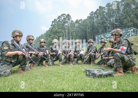 NANNING, CINA - 21 SETTEMBRE 2022 - ufficiali di polizia armati e soldati effettuano una trivella di salvataggio sul campo di battaglia di combattimento che si concentra sul tema dell'addestramento Foto Stock