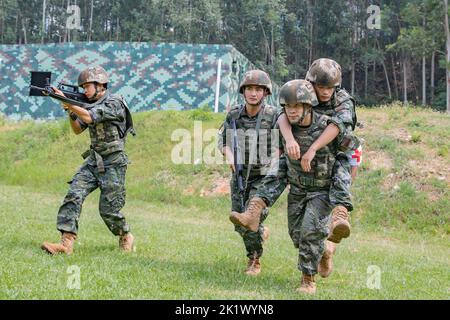 NANNING, CINA - 21 SETTEMBRE 2022 - ufficiali di polizia armati e soldati effettuano una trivella di salvataggio sul campo di battaglia di combattimento che si concentra sul tema dell'addestramento Foto Stock