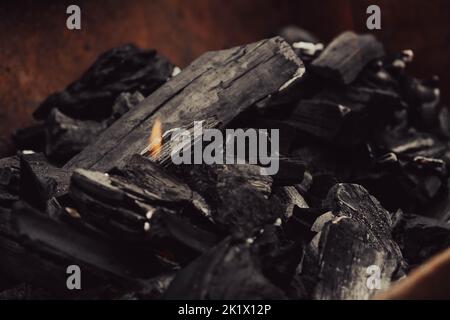 Legno che brucia. Il resto dell'alveare. Legna da ardere. Ceneri nel cavoldro. Resti del fuoco. Foto Stock