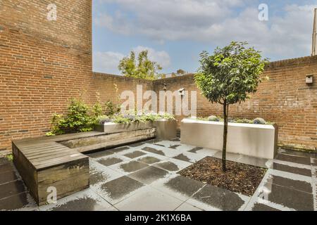 Patio semplice con piccolo giardino vicino a recinzione di legno Foto Stock